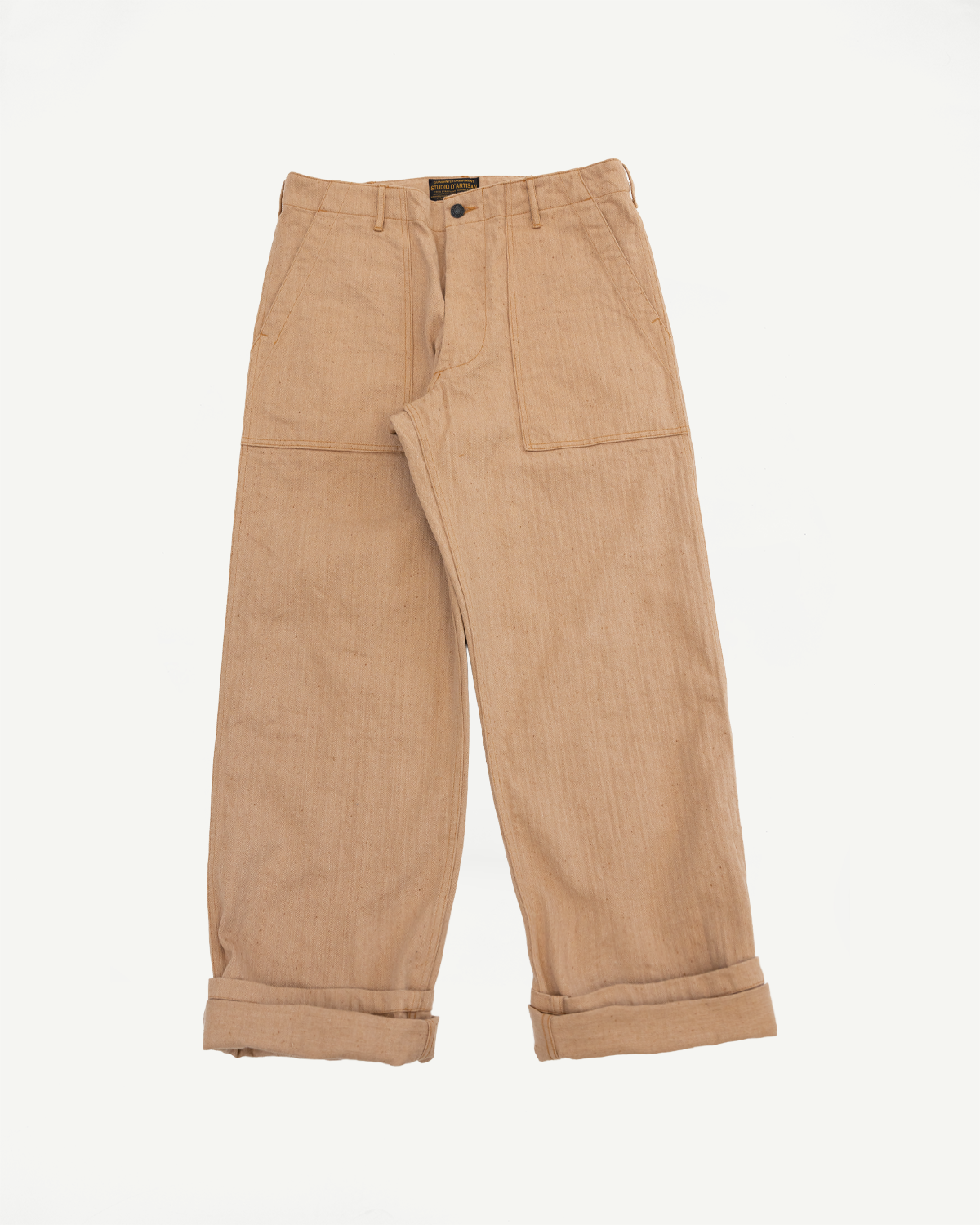 Tan workwear pants, front view flat lay. Wide legs, cuffed hems, button fly, visible brand tag at waist.