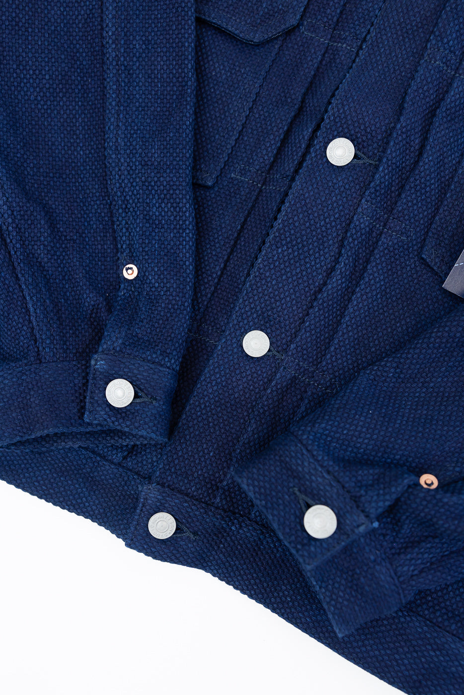 Navy blue textured shirt close-up, front view showing button details, collar, and sleeve cuff