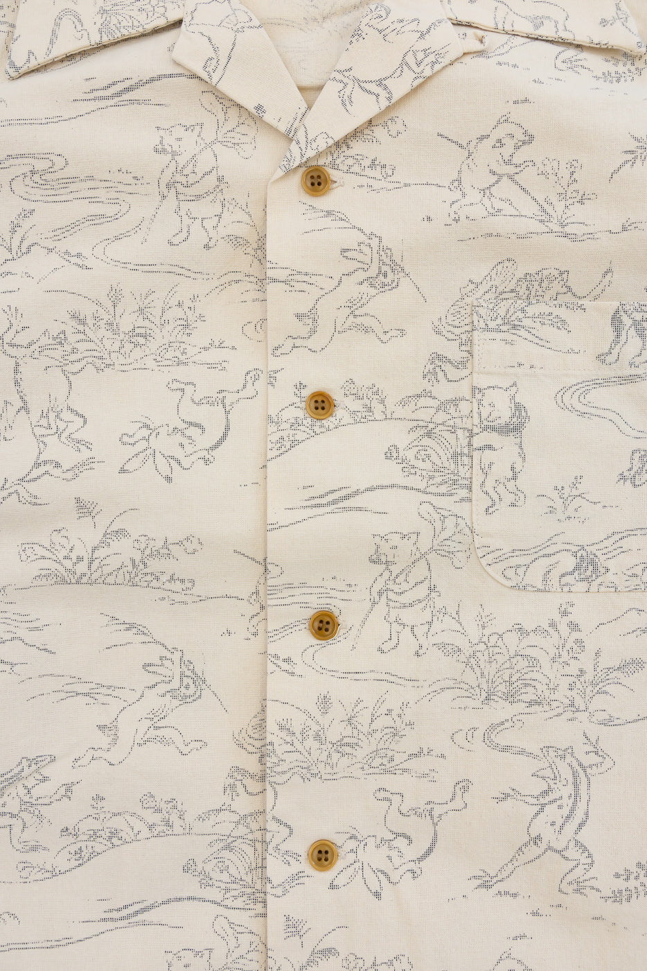 Close-up front view of cream shirt with animal print, button details, and chest pocket
