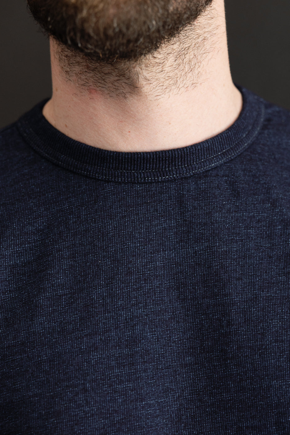 Close-up front view of navy crew neck tee on male model, 5'9