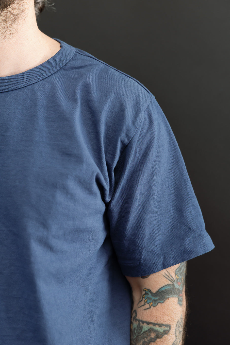 Close-up front view of navy blue tee on male model, 5'9