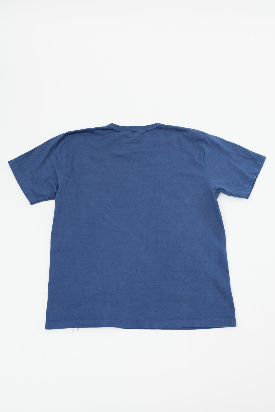 Flat lay back view of navy blue short-sleeve t-shirt with tag detail, showcasing fabric texture and hem