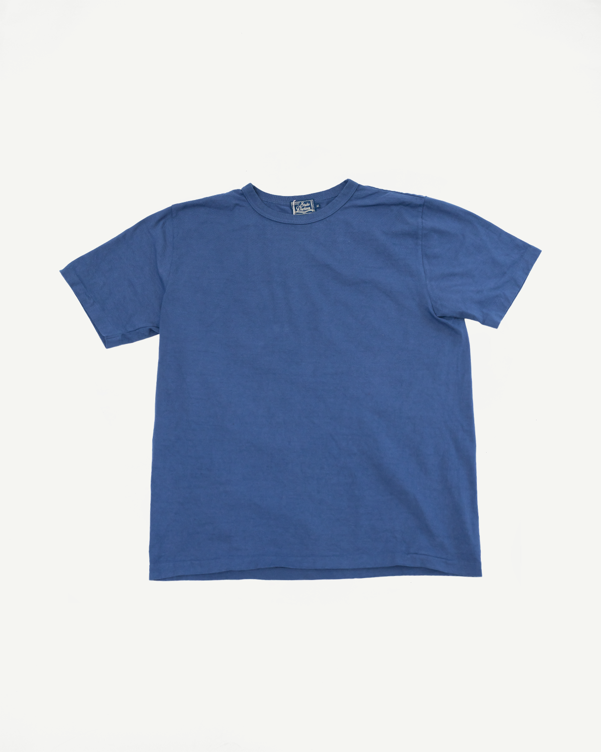 Flat lay front view of blue crew neck t-shirt with visible brand tag, showcasing fabric texture and hem detail