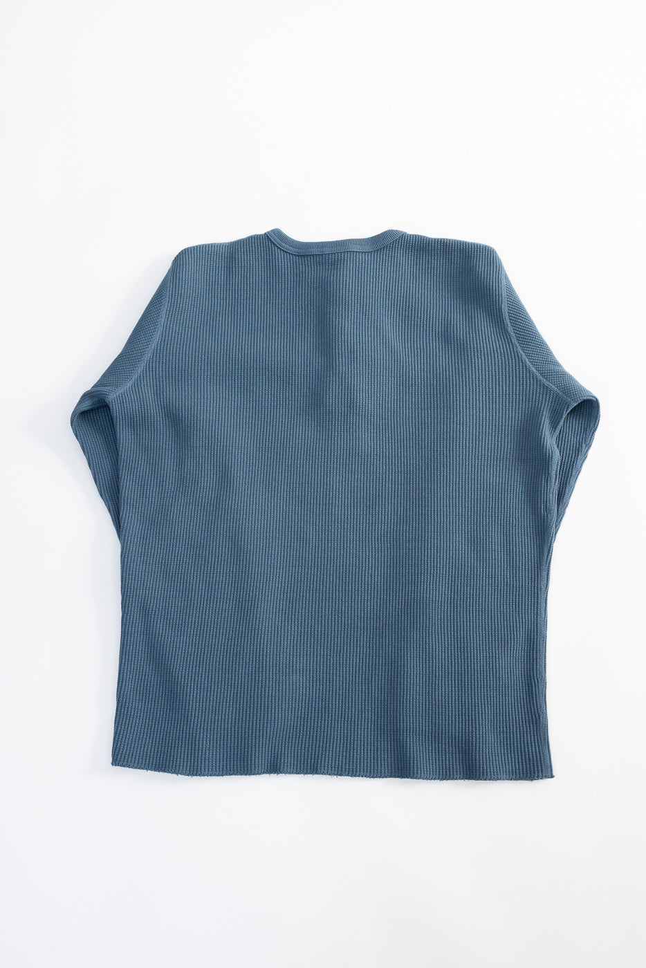 Flat lay of Studio D’Artisan heavy thermal blue long sleeve Henley, back side, textured fabric