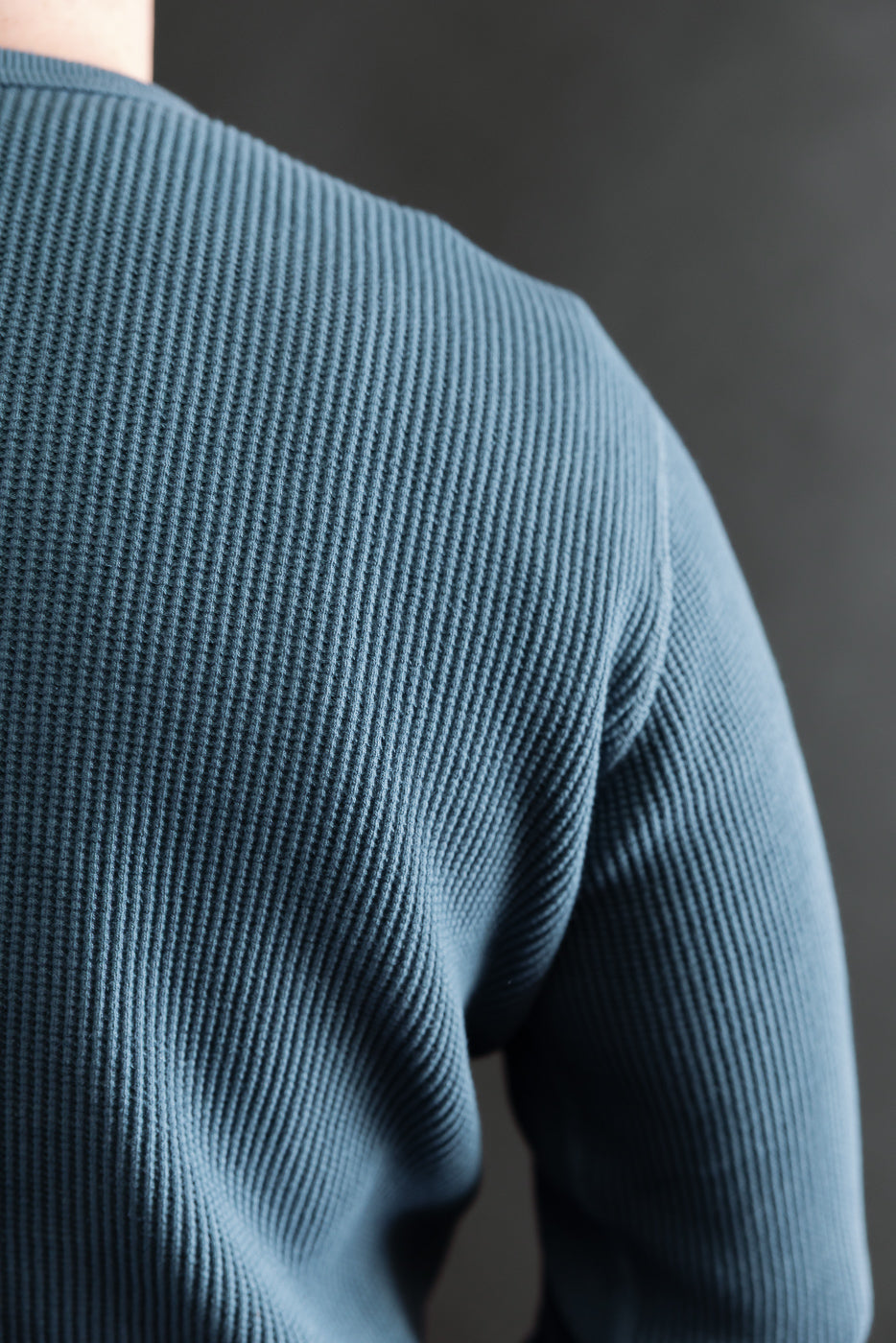 Close-up of male model's back wearing blue Studio D'Artisan heavy thermal long sleeve, highlighting textured fabric and shoulder seam.