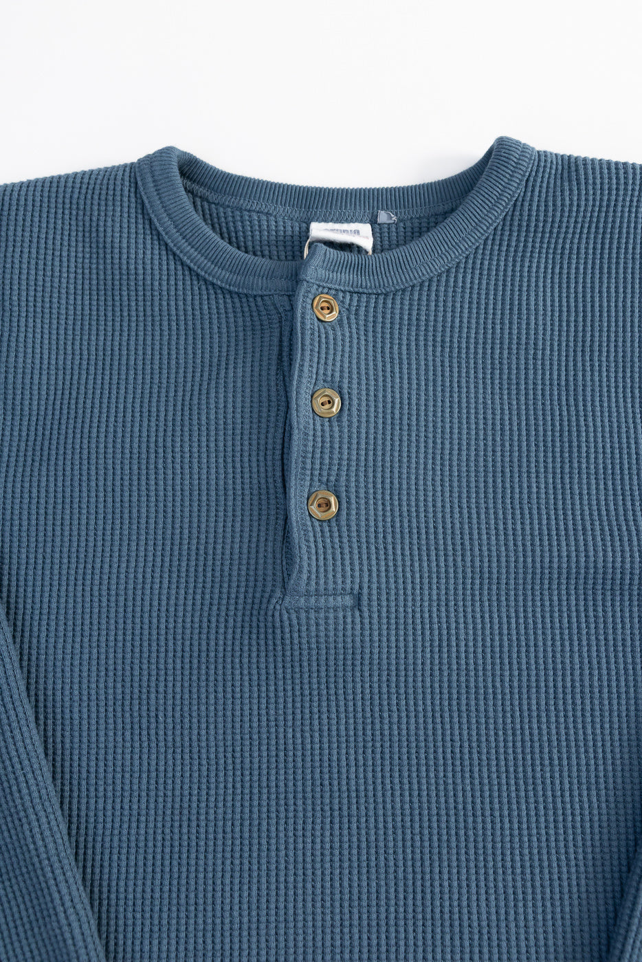 Close-up front of Studio D’Artisan heavy thermal henley in blue, showing buttons and textured fabric