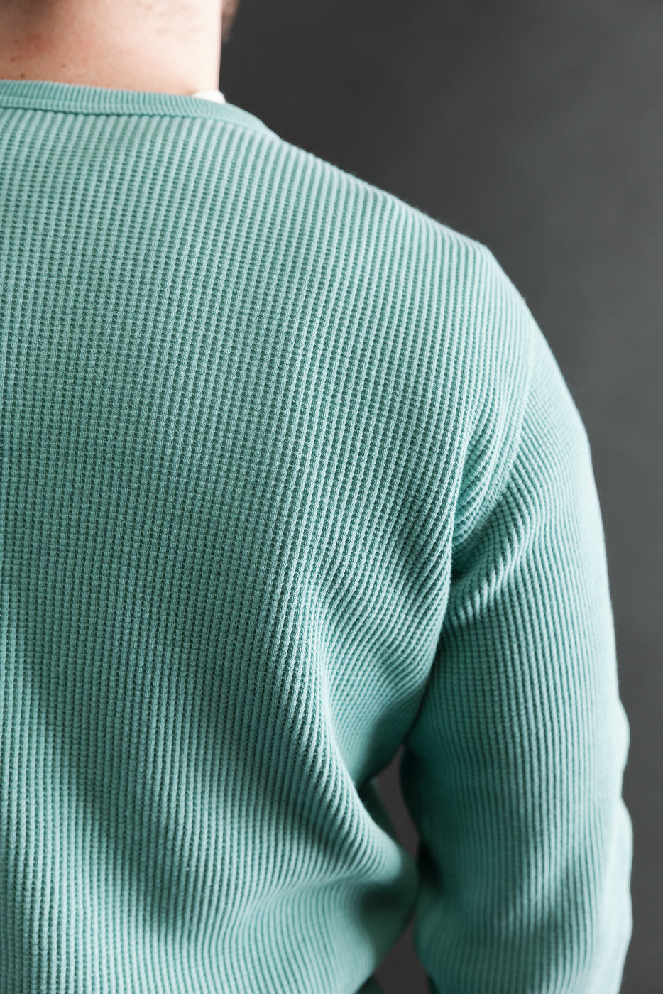 Close-up of heavy thermal emerald long sleeve henley, back side, on male model 5'9