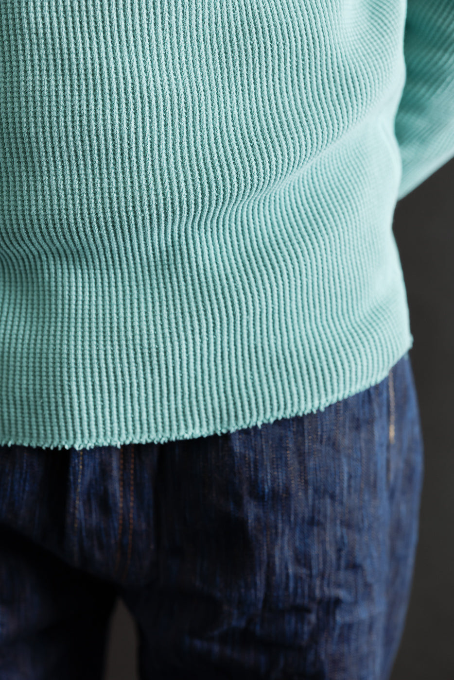Close-up front view of Studio D'Artisan emerald heavy thermal Henley hem texture on male model