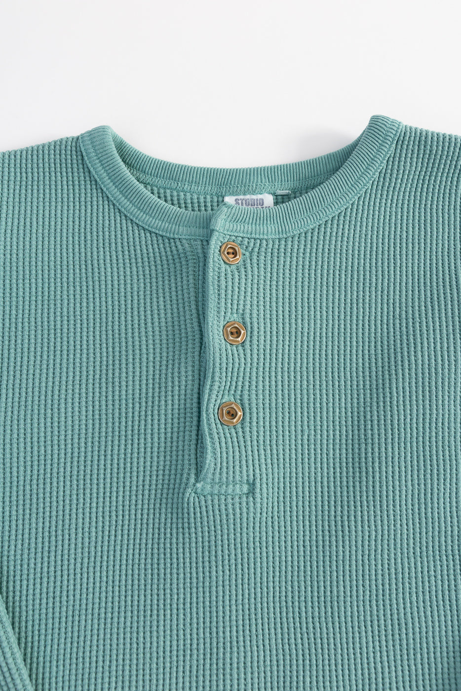 Close-up front of Studio D'Artisan emerald heavy thermal Henley, showing fabric texture, buttons, and collar detail