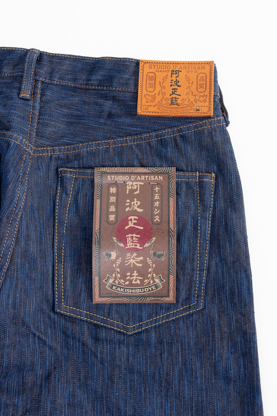 Close-up of Studio D'Artisan indigo selvedge jeans back, showing pocket and leather patch.