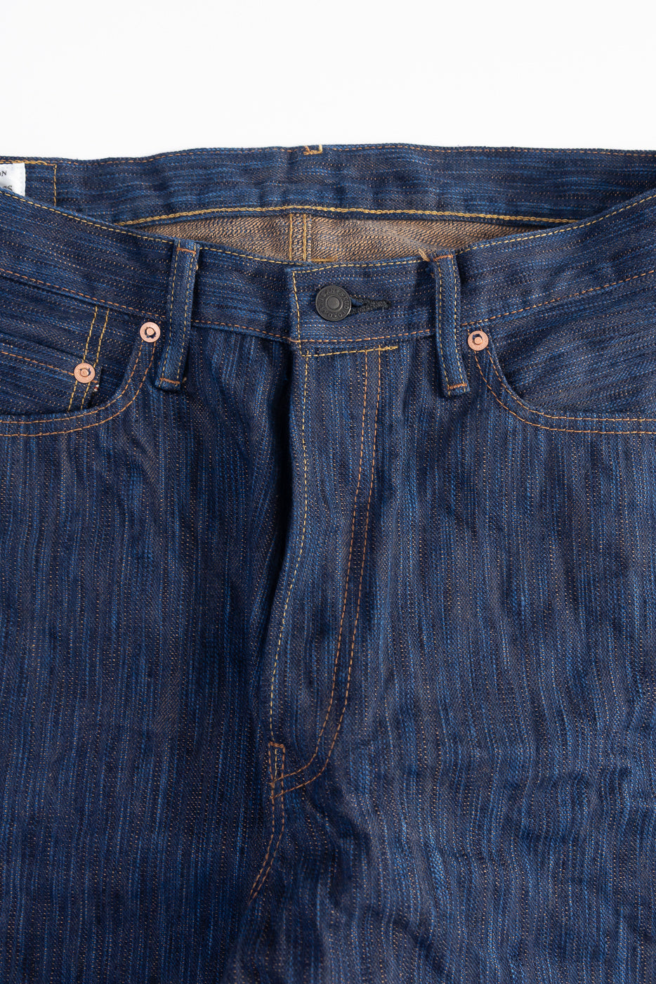 Close-up of front waistband and pocket details on Studio D'Artisan 15oz indigo selvedge jeans.