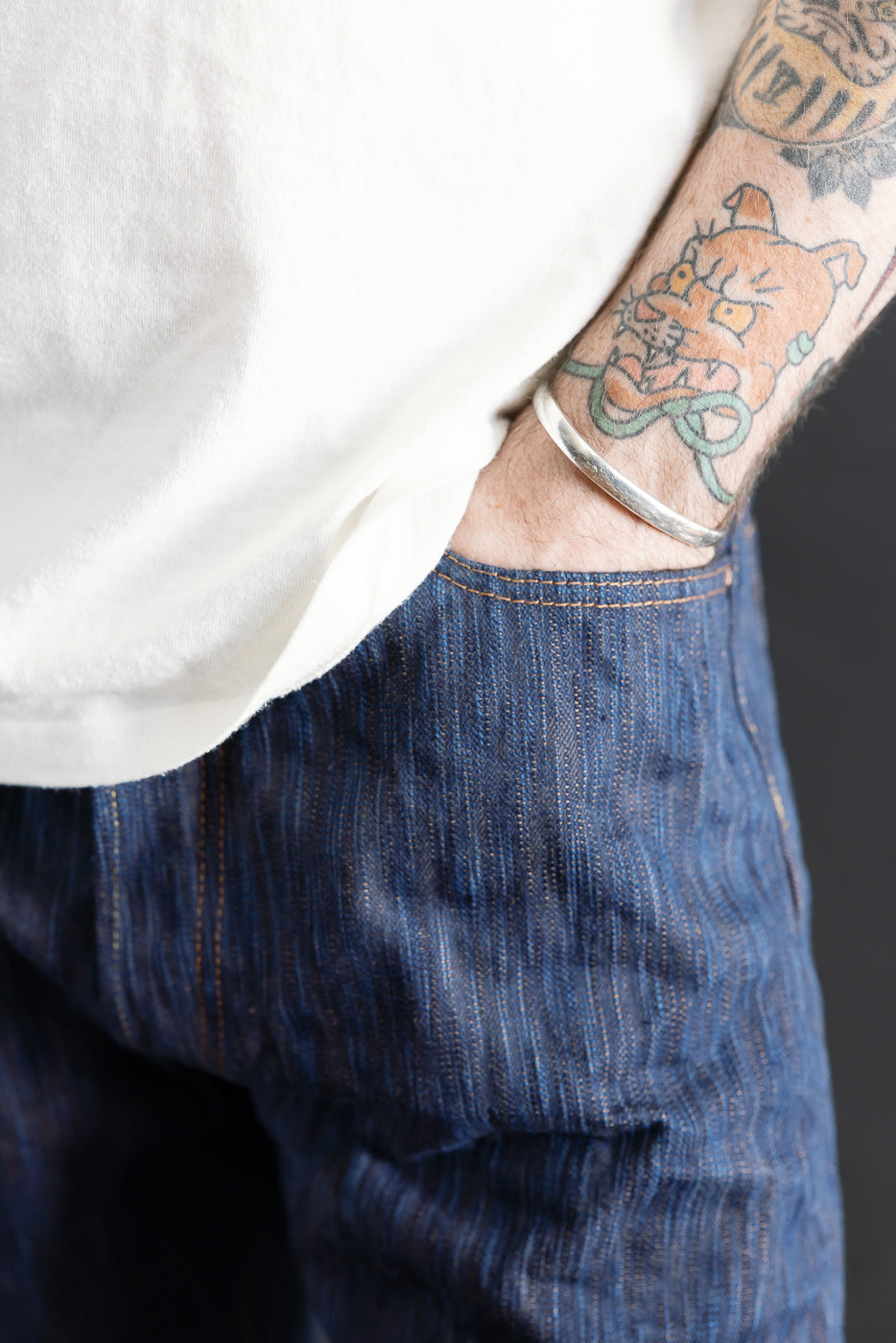 Close-up front view of Studio D'Artisan indigo selvedge jeans pocket on male model, 5'9