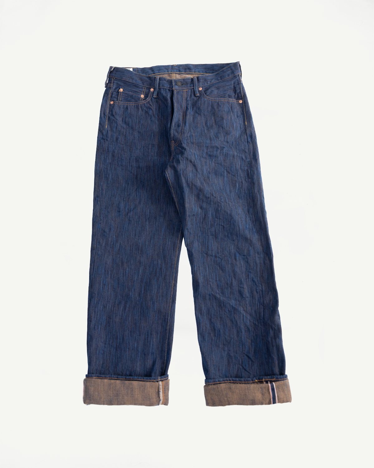 Flat lay front view of Studio D'Artisan 15oz selvedge jeans, cuffed hems, natural indigo denim.