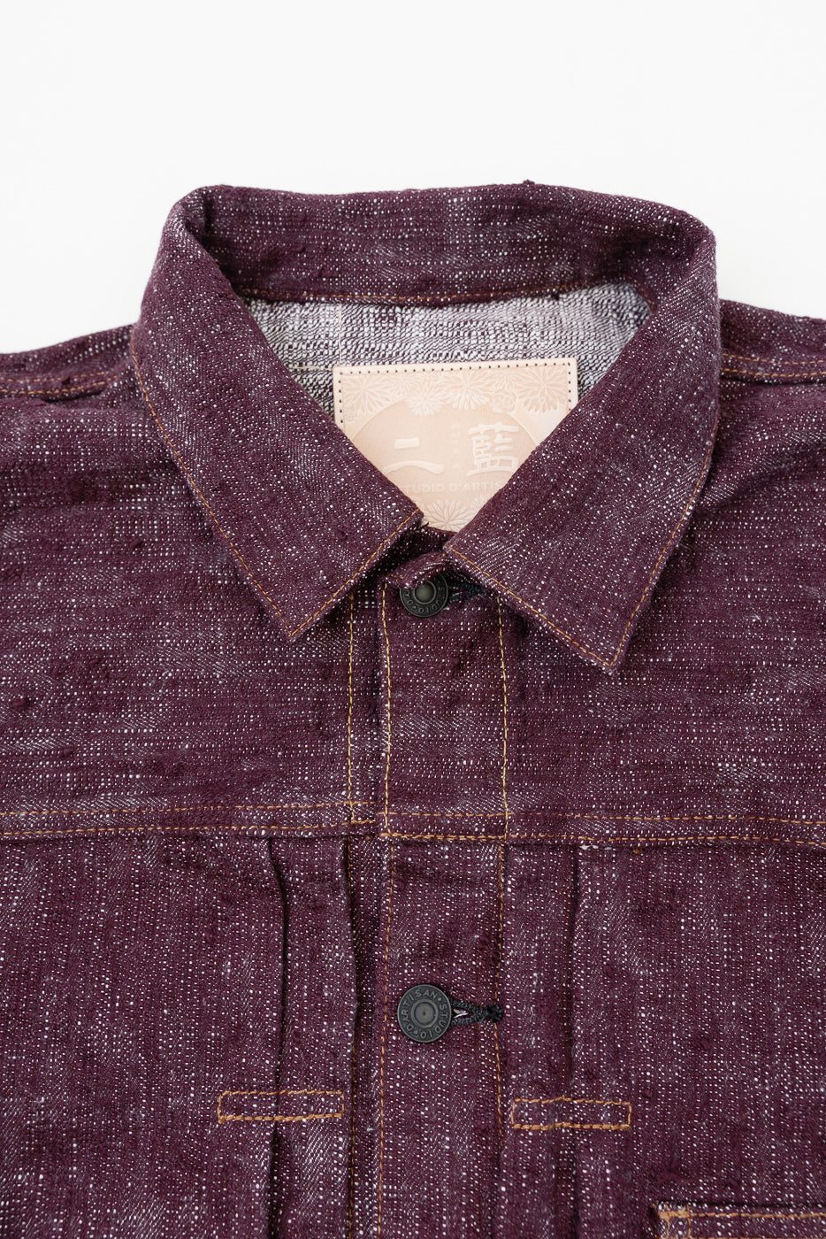 Close-up front view of deep burgundy selvedge shirt, showing collar, button placket, contrast stitching, and brand tag