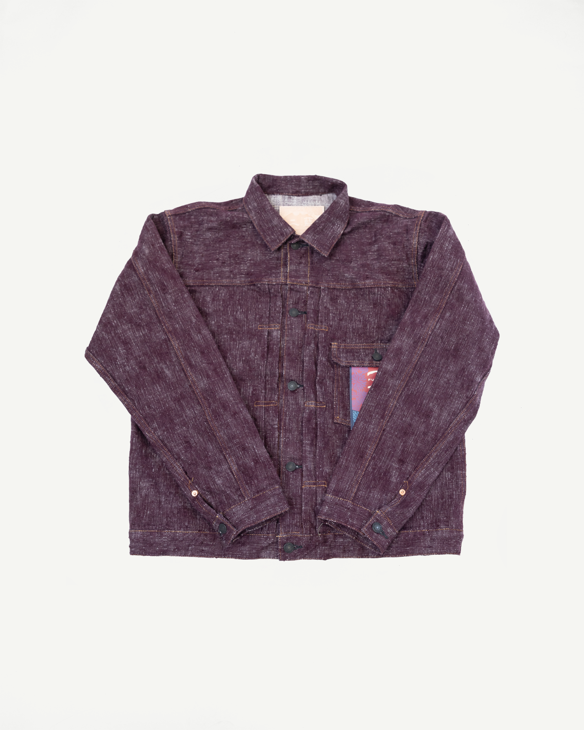 Flat lay front view of purple selvedge work jacket with button closure, chest pocket, and contrast stitching