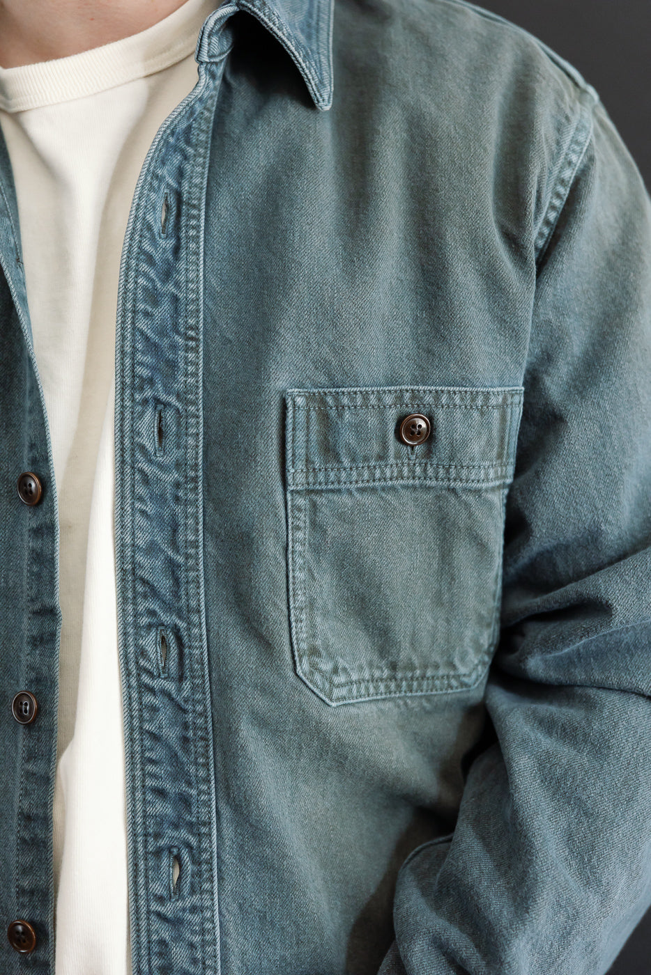 Close-up front view of a blue denim shirt on a male model, 5'9