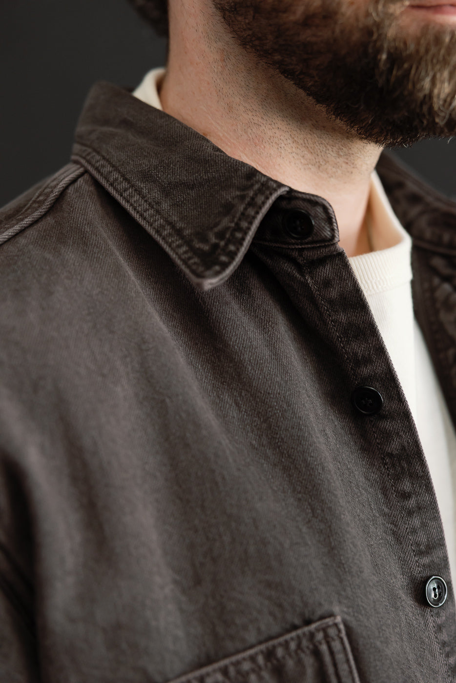 Close-up of front right side of a charcoal denim shirt on a male model (5'9
