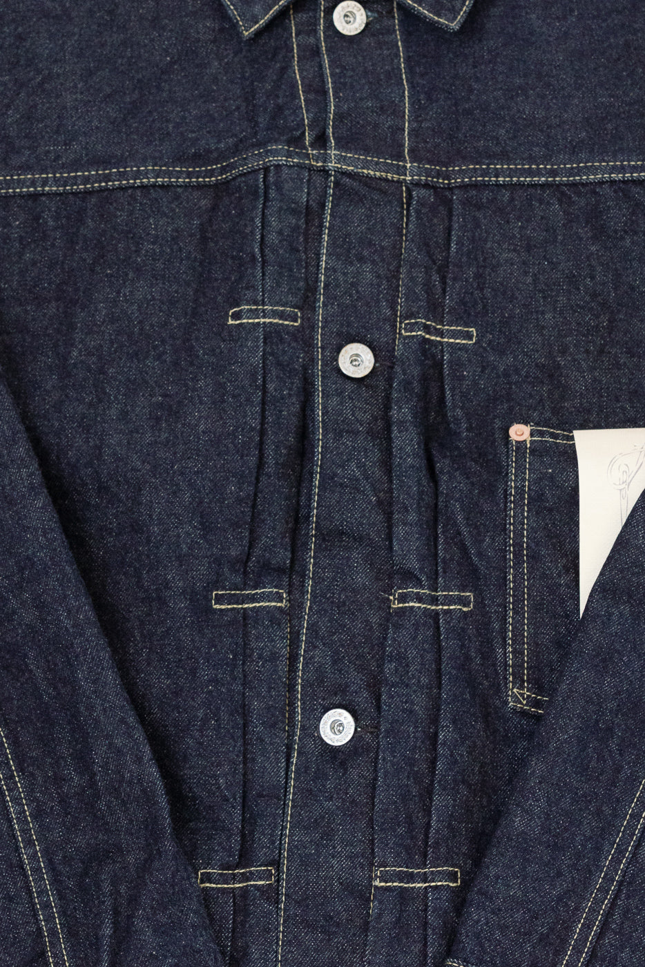Close-up front view of dark selvedge denim shirt, showcasing button placket, contrast stitching, and chest pocket detail.
