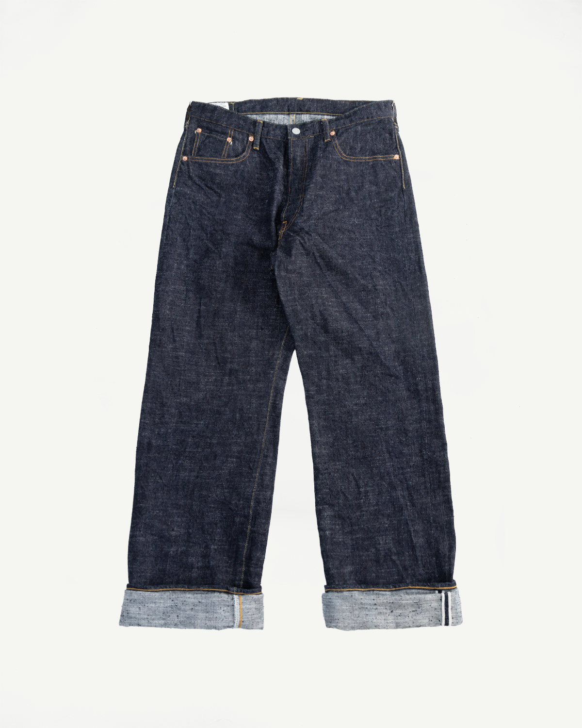 Flat lay front view of loose straight selvedge jeans, cuffed hem, dark indigo denim.