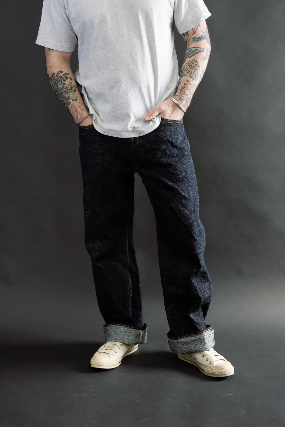 Full body front view of loose straight selvedge jeans on male model, 5'9