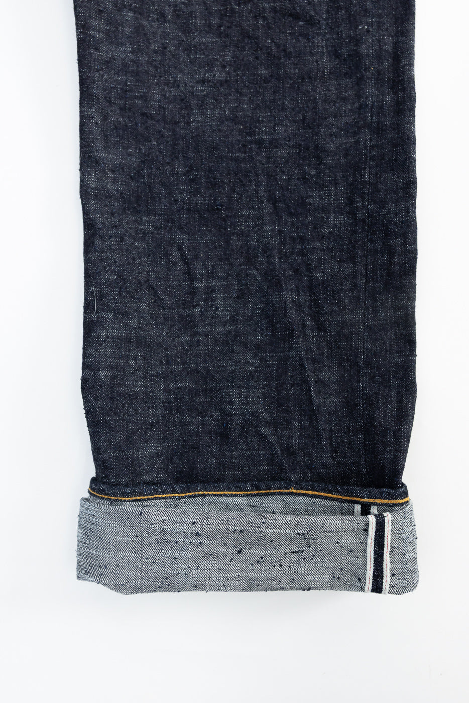 Close-up of selvedge denim jeans cuff, showing hem stitching and fabric edge detail