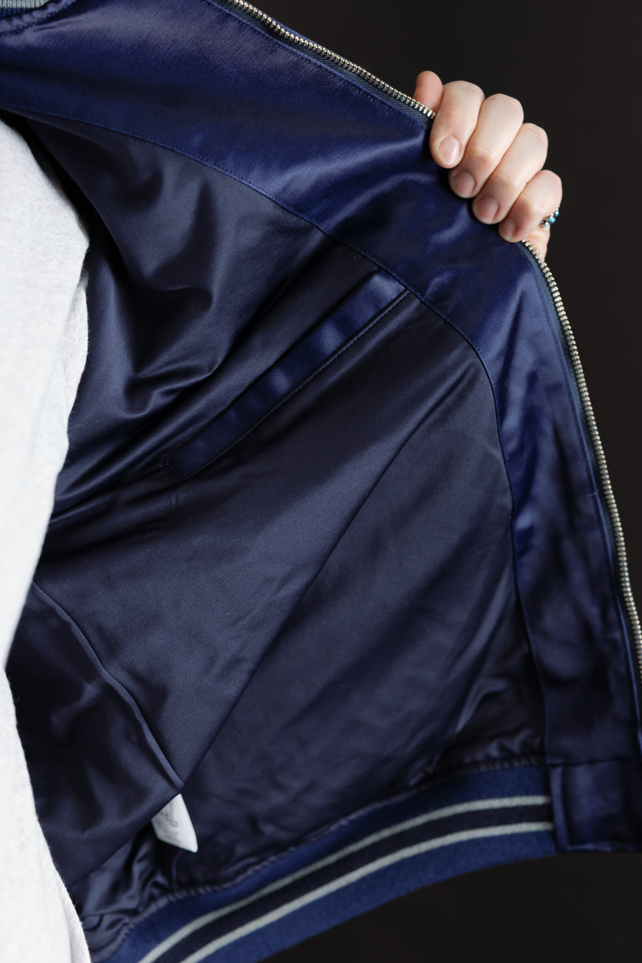 Close-up of inner lining and pocket detail of indigo satin sukajan jacket, inside front view.