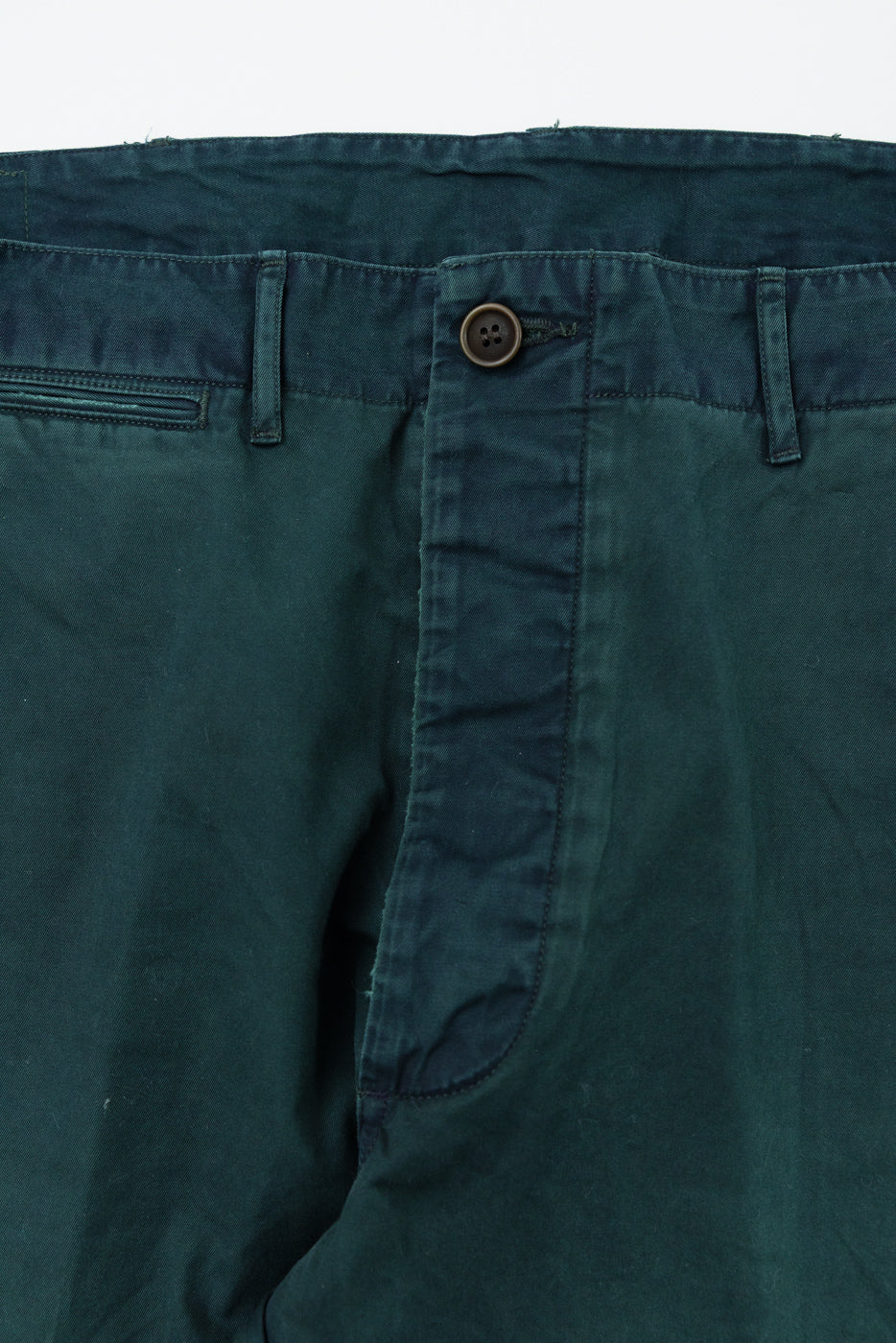 Close-up front view of dark green men's chinos showing button, waistband, and pocket details