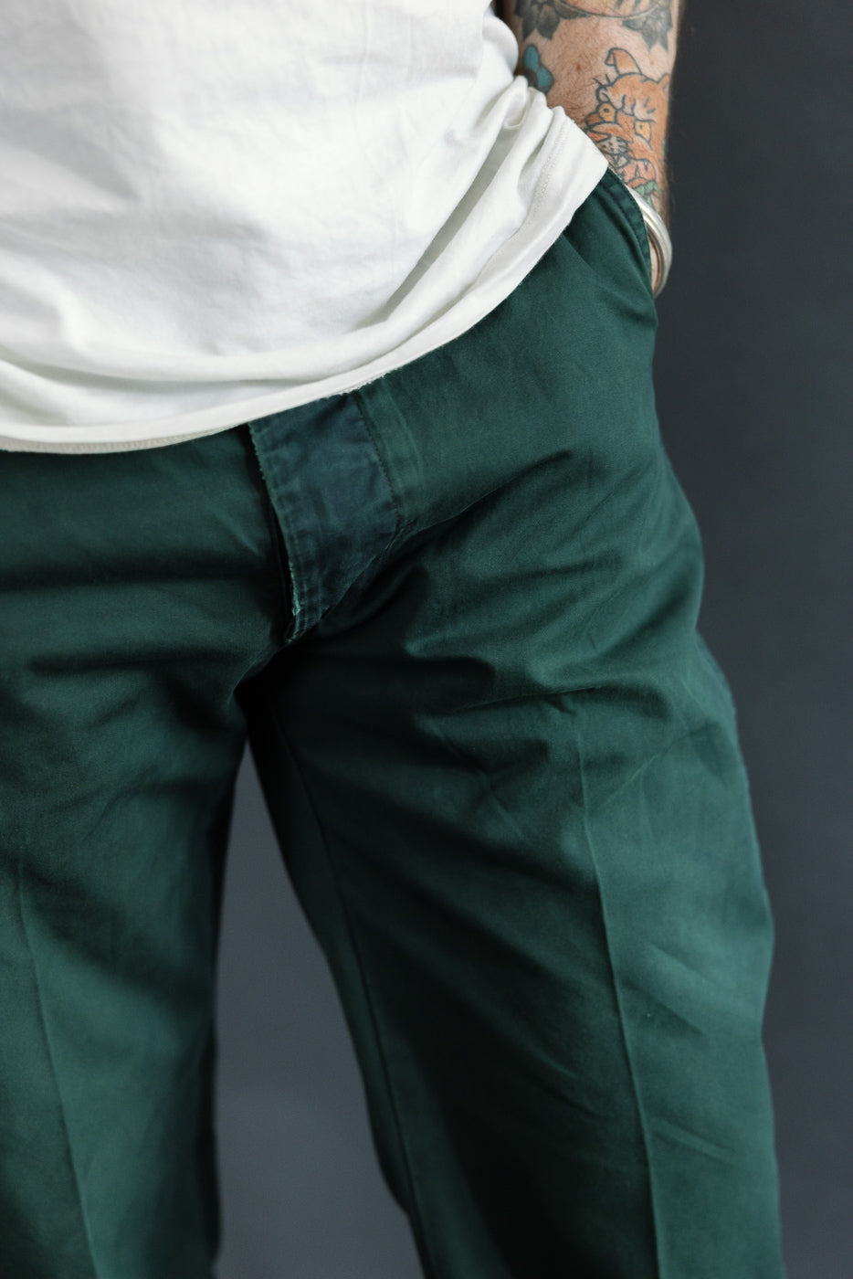 Close-up front view of dark green casual pants on male model, 5'9