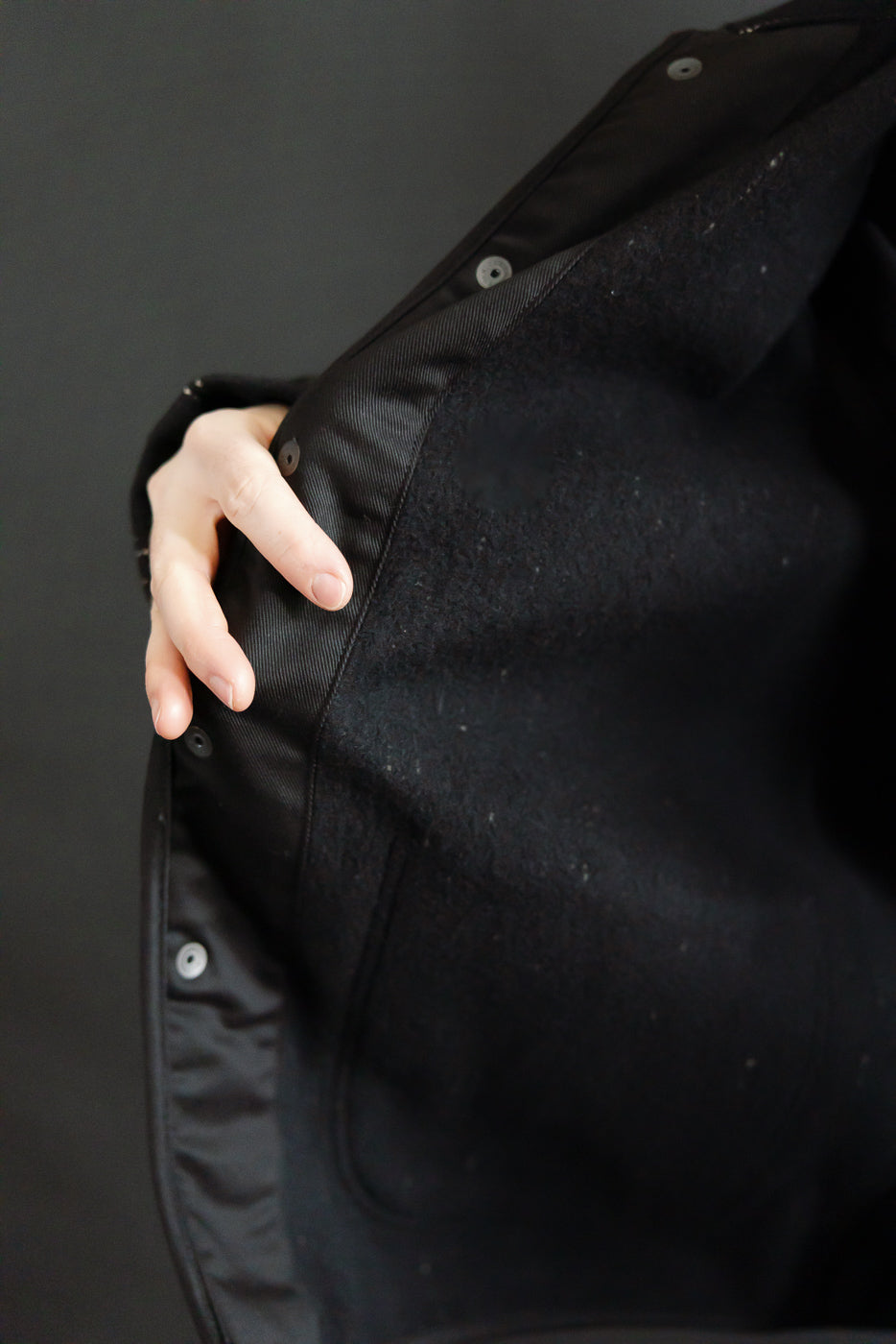Close-up of the interior front lining and pocket detail on black Studio D’Artisan coverall.