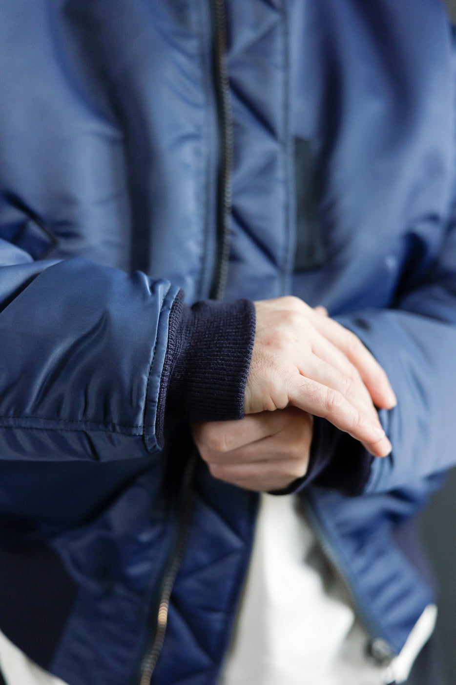 Close-up of Studio D'Artisan indigo MA-1 flight jacket cuff, male model, front side.