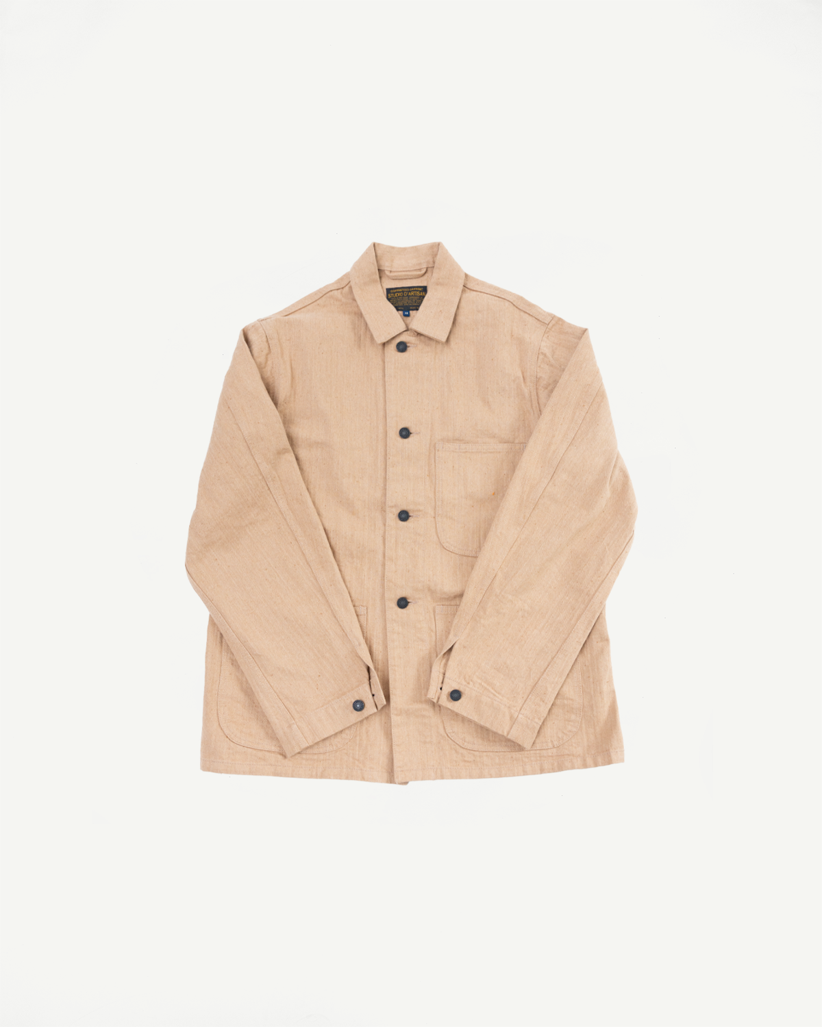 Tan work jacket flat lay, front view: button-up, collar, chest pocket, sleeve cuffs, selvedge fabric detail