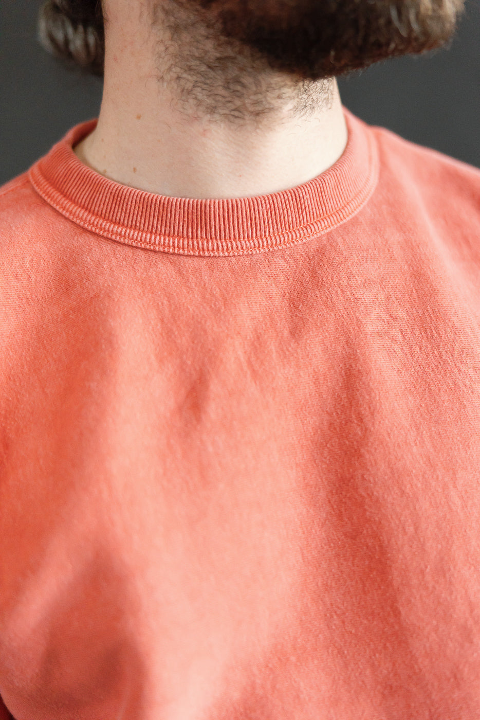 Close-up front of Studio D'Artisan red sweatshirt on male model, crewneck collar detail, athletic build
