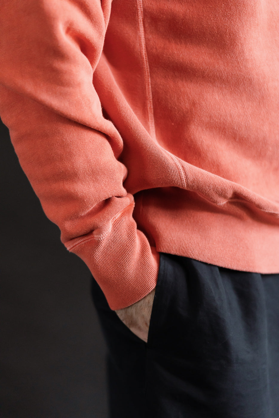 Close-up of men's red Studio D'Artisan Bengara reverse weave sweatshirt sleeve and hem, side view, on 5'9