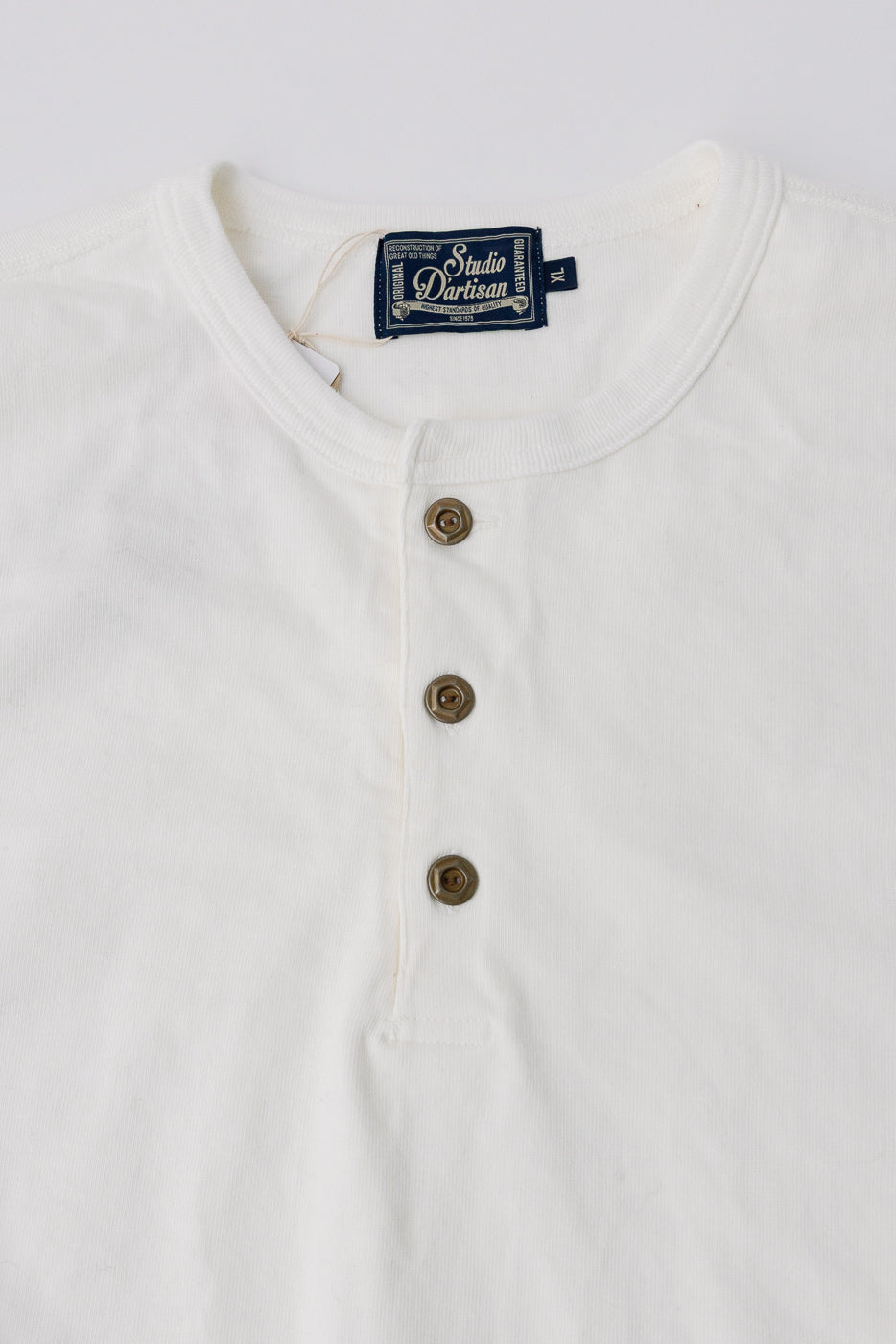 Close-up of Studio D'Artisan Suvin Gold LS Henley in white, front buttons, collar, fabric texture.