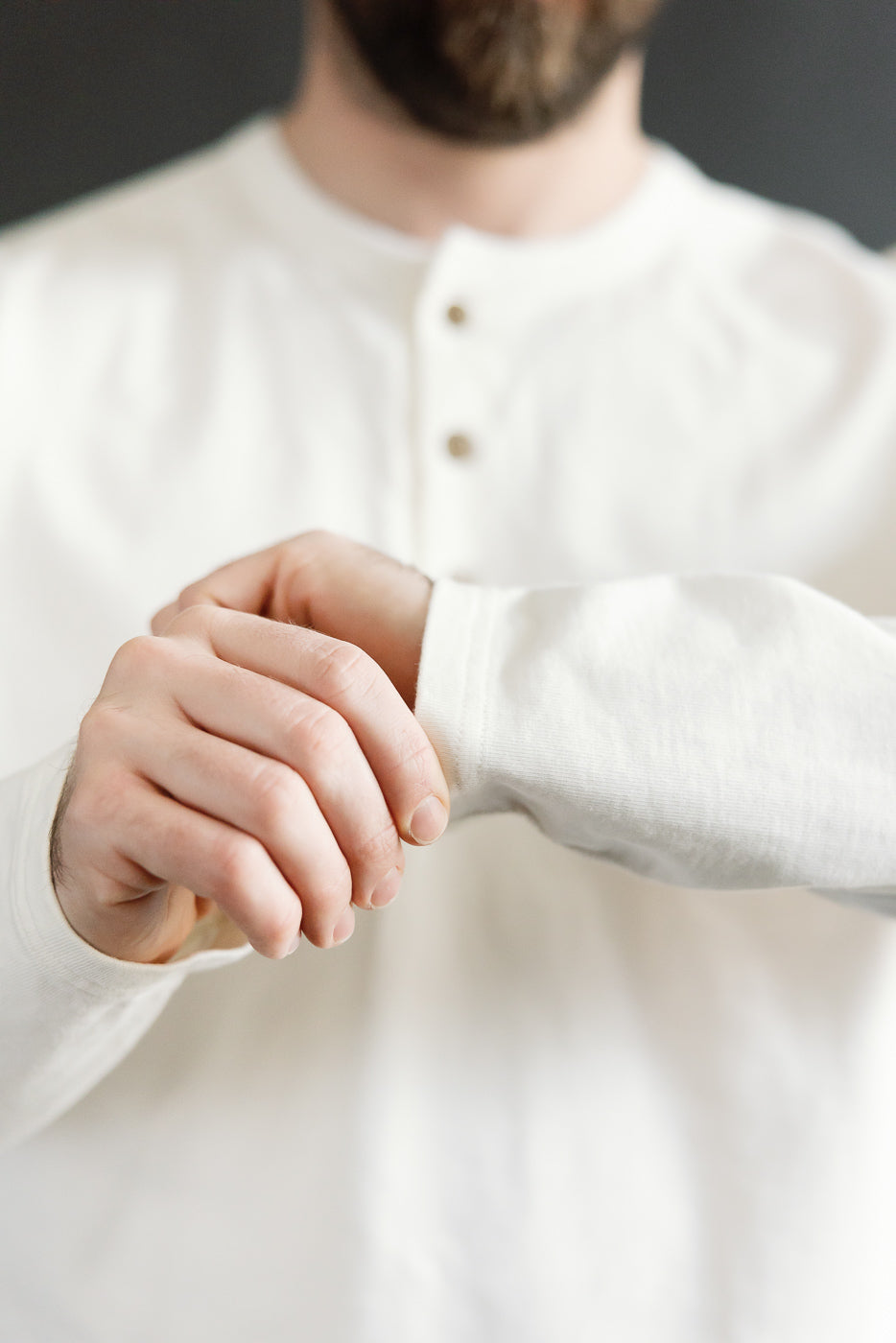 Close-up front view of Studio D'Artisan Suvin Gold LS henley in white, on male model 5'9