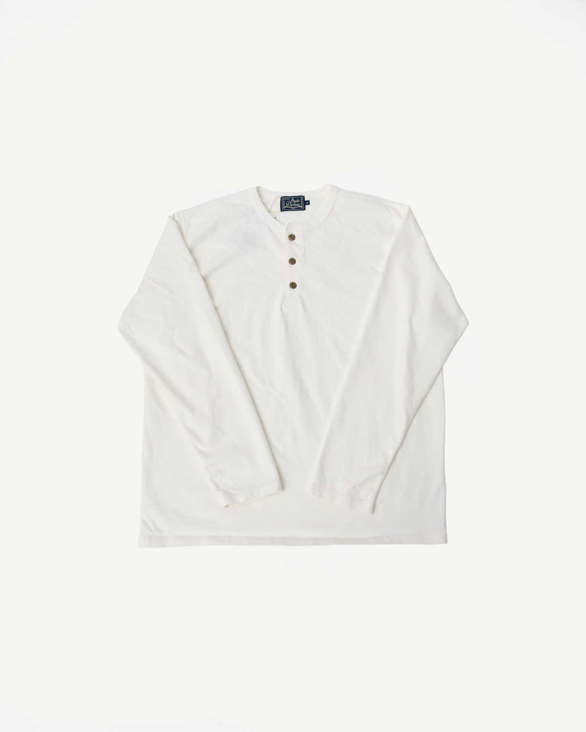 Flat lay of Studio D'Artisan 8187 Suvin Gold white long sleeve henley, front view, showing button placket and crew neck.