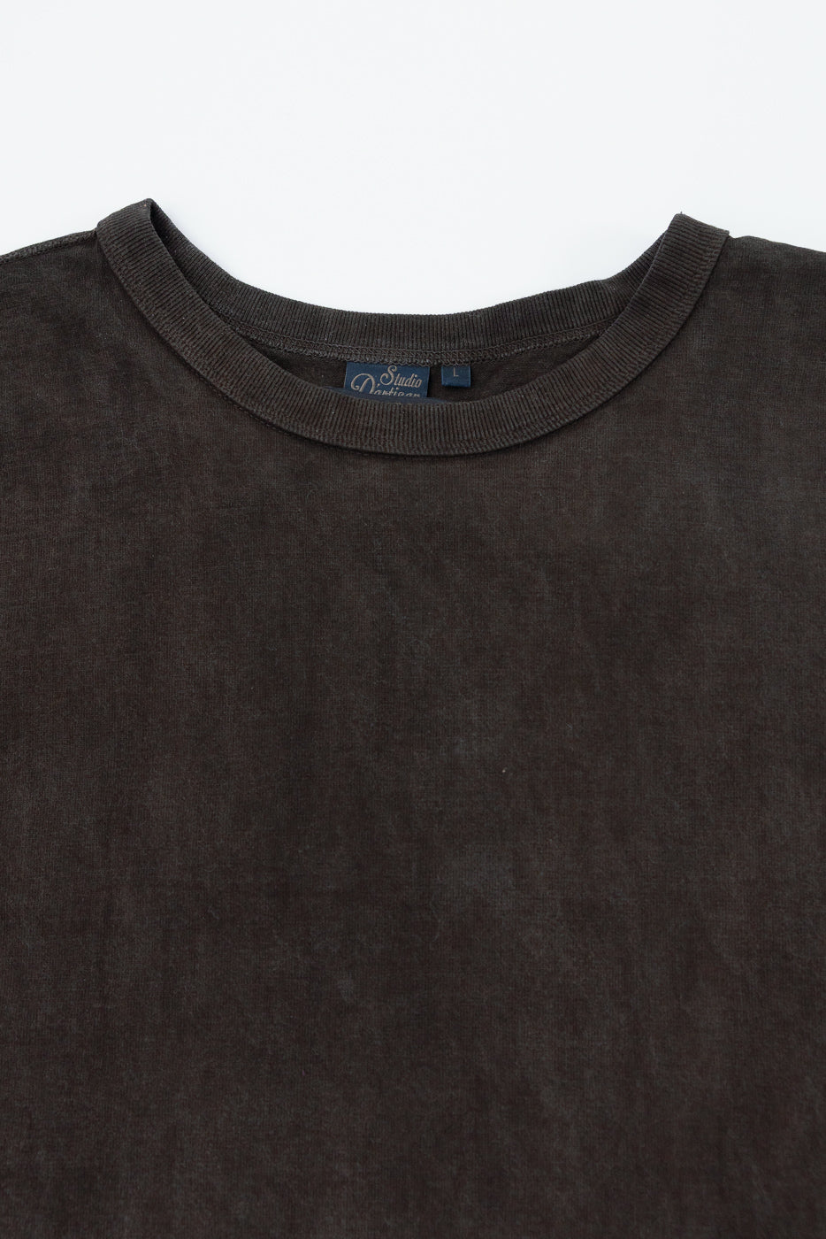 Close-up front view of dark brown crew neck tee, showing tag details and ribbed collar texture
