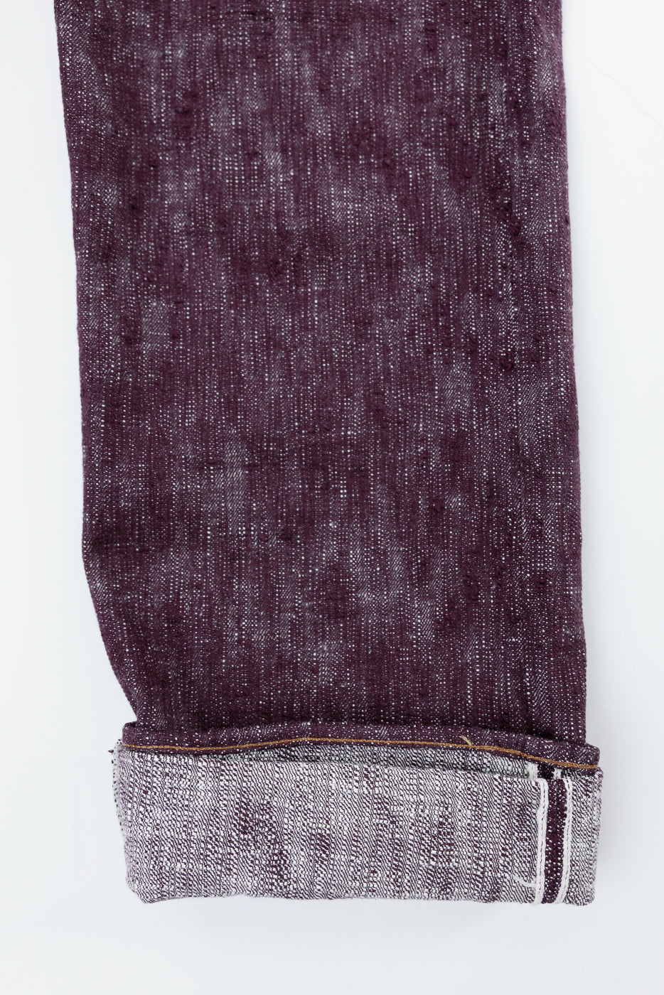 Close-up of selvedge denim jeans hem, showcasing texture and stitching detail