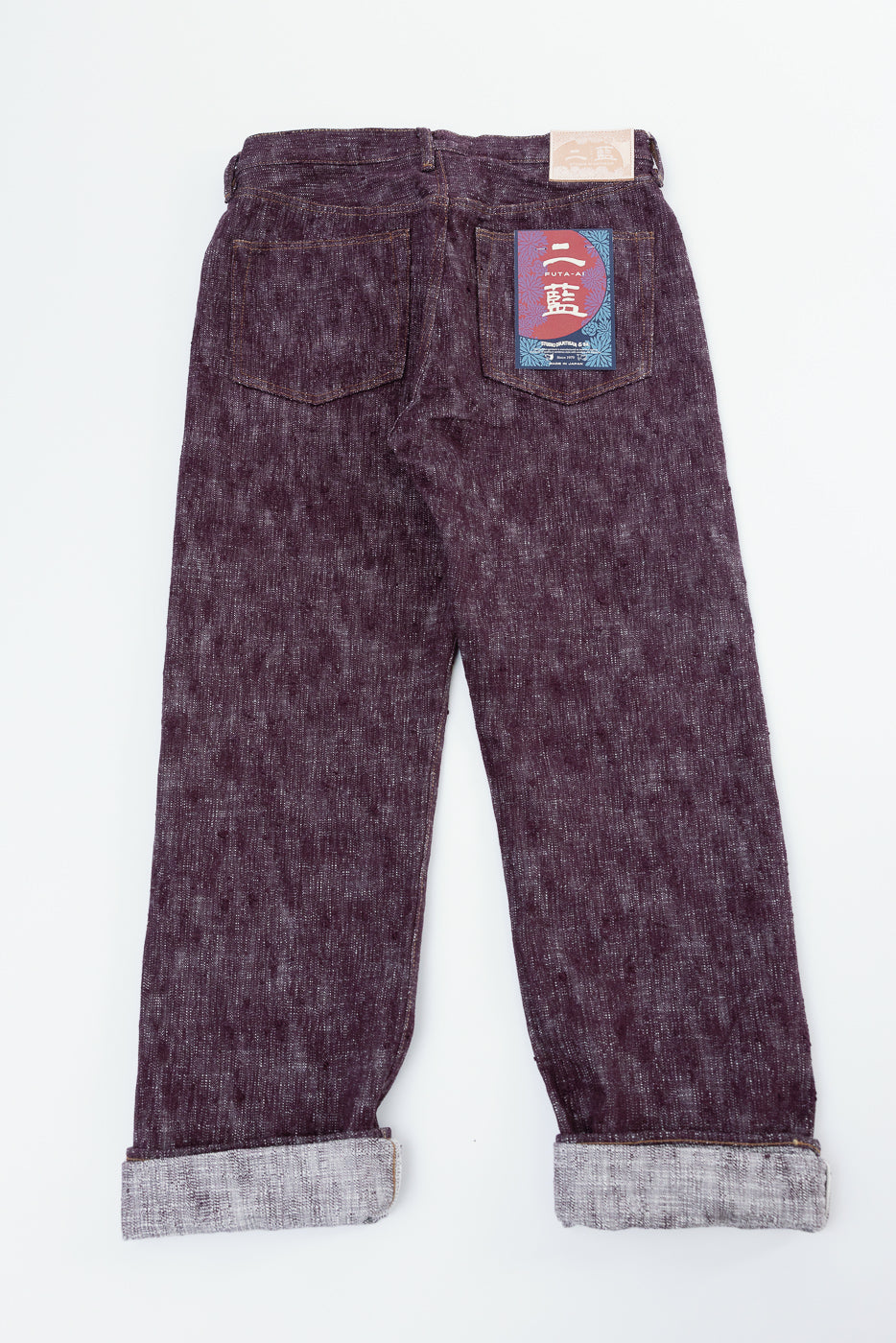 Back view of selvedge jeans with cuffed hems and branded patch on rear pocket