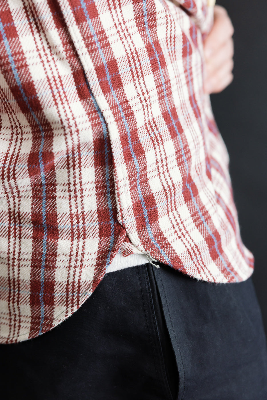 Close-up of maroon plaid flannel shirt hem, left side, on male model 5'9