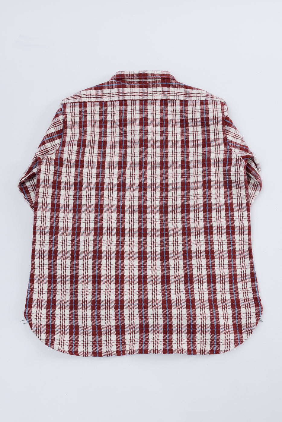Flat lay of maroon plaid flannel shirt, back view, showing fabric pattern and straight hem.