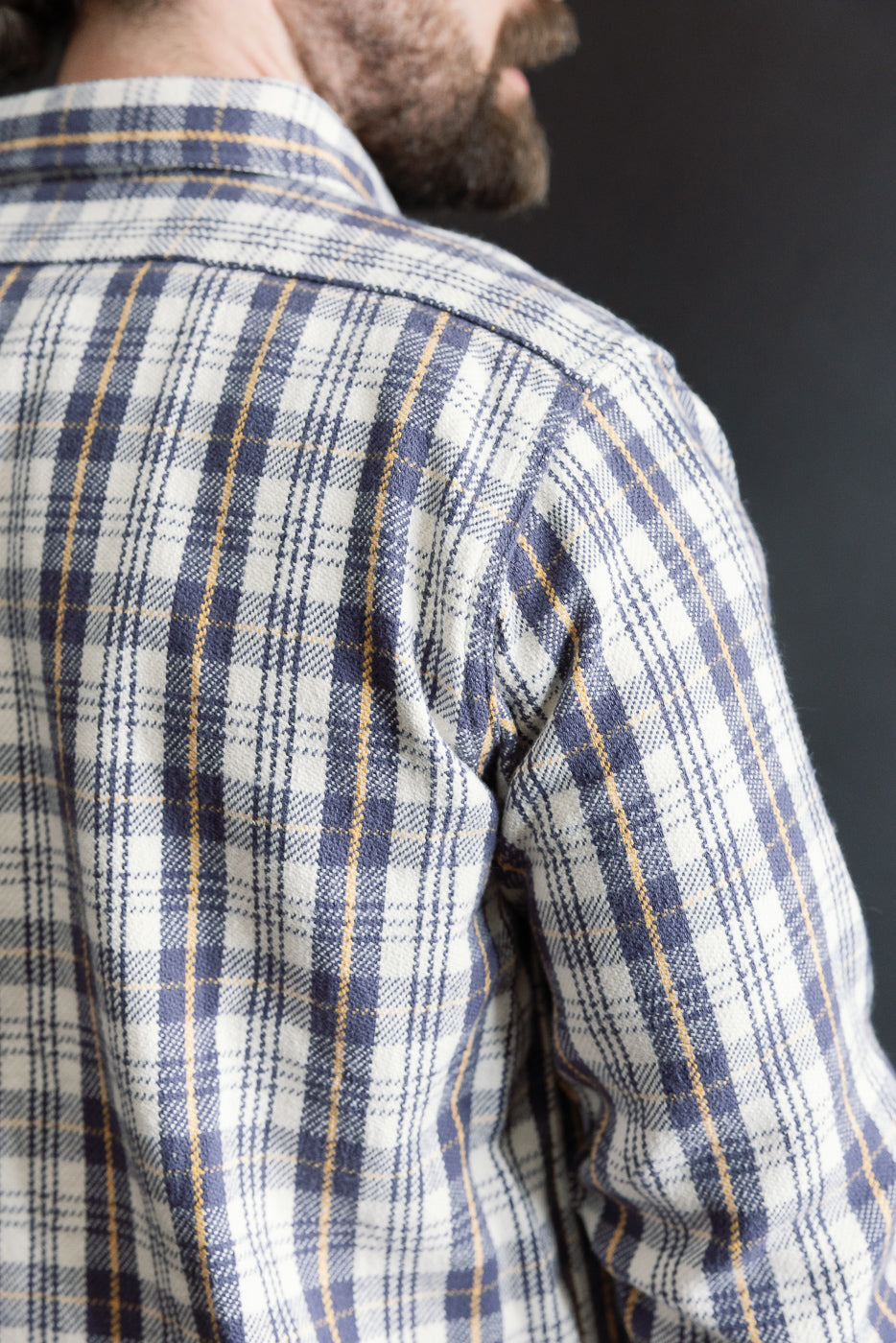 Close-up of back shoulder of navy and cream plaid flannel shirt on male model, 5'9