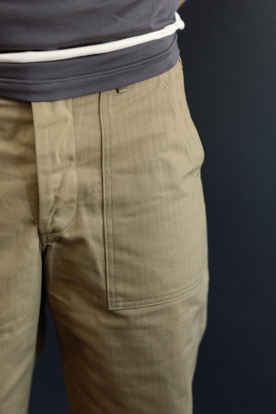Close-up of male model's side, showing olive cargo pants with front pocket detail, 5'9