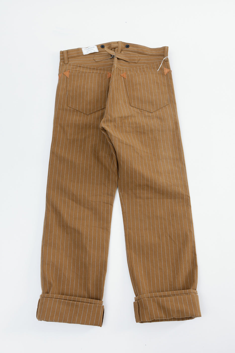 Flat lay of duck stripe work trousers, back side, showing rear pockets and cuffed hems.