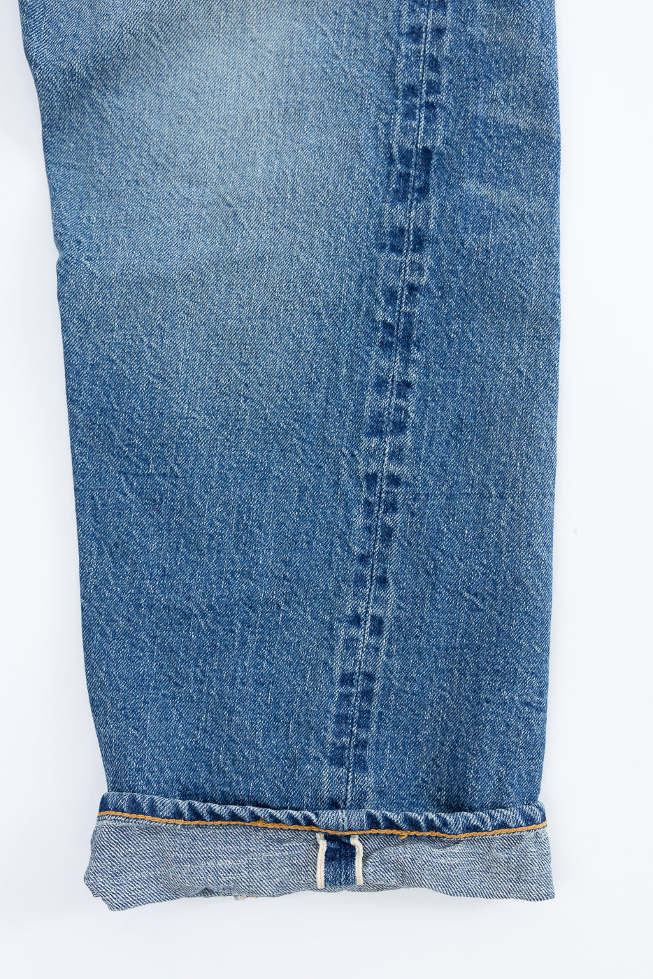 Lot 2nd-Hand 1105 - 12oz Used Washed Indigo Denim - Tapered Fit: Close-up of rolled-up selvedge hem showing contrasting stitching, evoking a vintage 1960s style with authentic, lived-in fading.