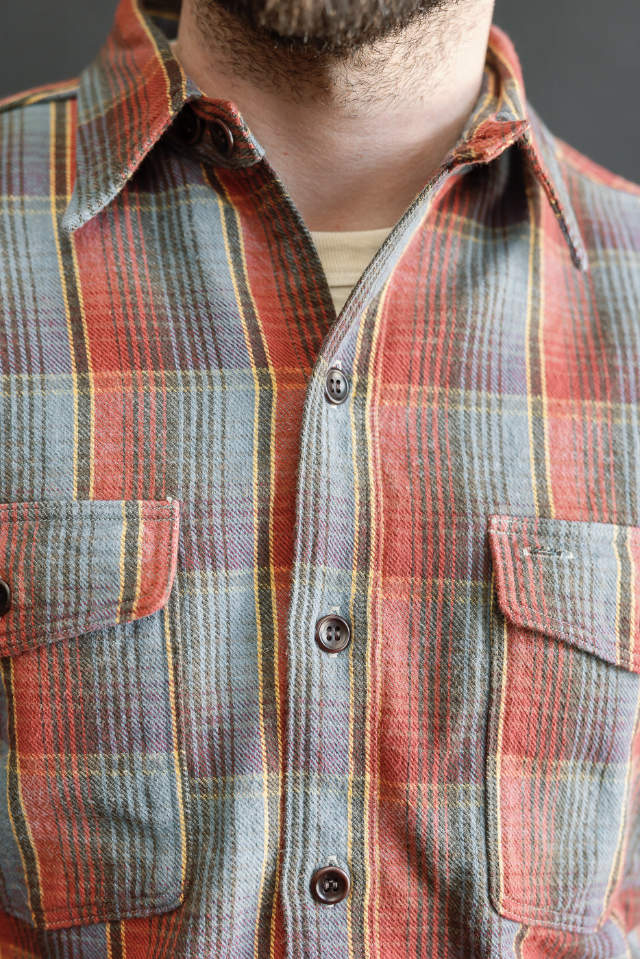 Close-up of the Warehouse & Co. Lot 3022 Flannel Shirt with a chinstrap G pattern, showcasing red, navy, and yellow plaid, button-flap chest pockets, and dark buttons, emphasizing heritage-inspired craftsmanship.