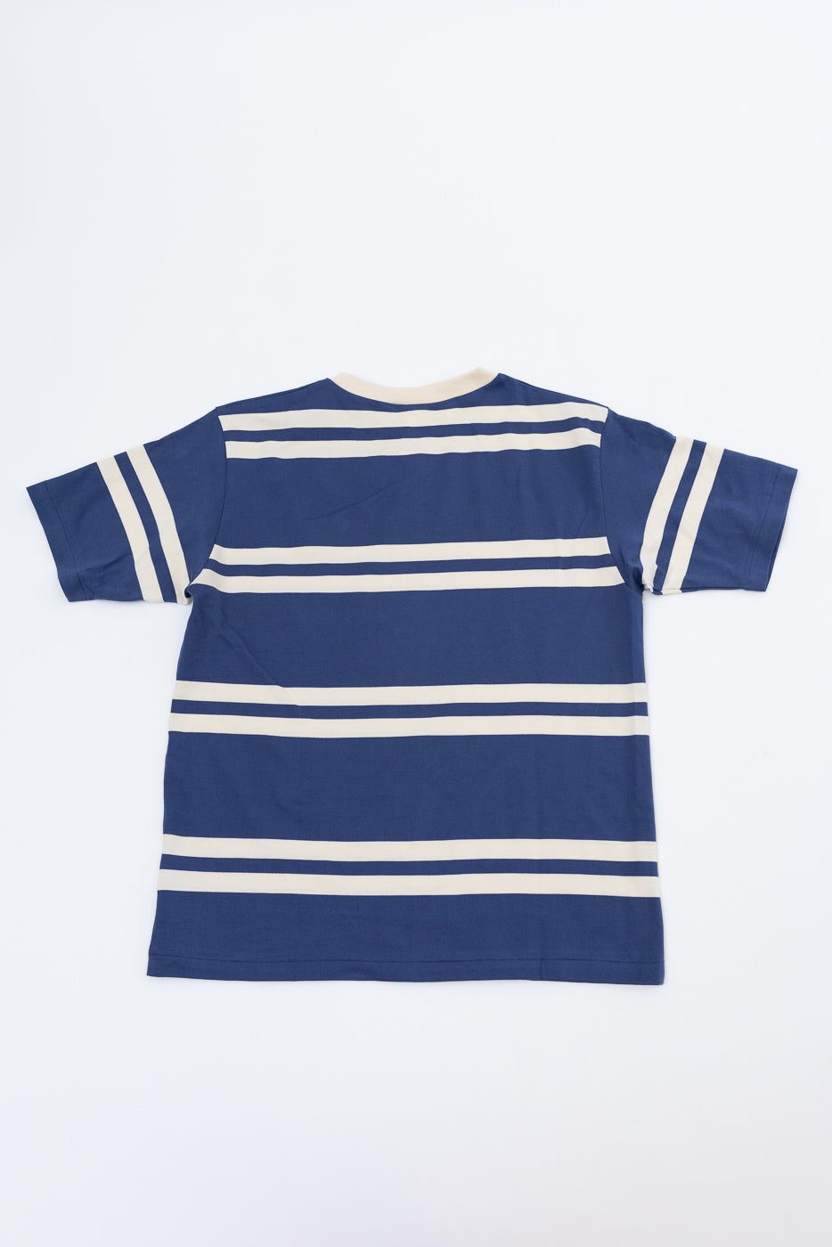 Back view of navy blue and cream striped t-shirt, flat lay, showcasing horizontal stripes and sleeve details.