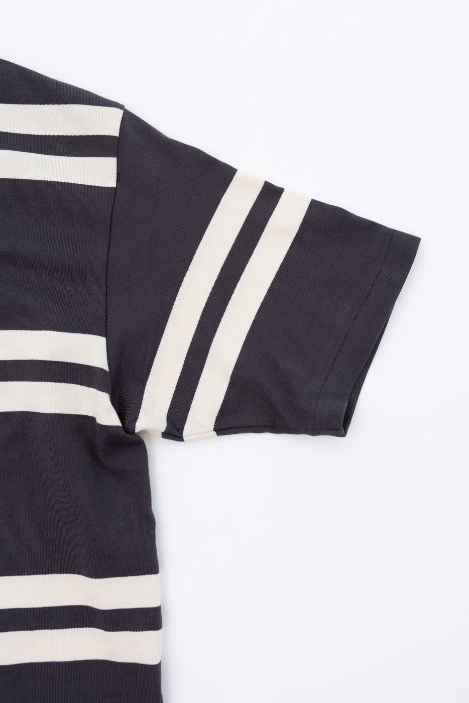 Close-up front view of navy & cream striped short sleeve tee, showing sleeve hem and ribbed texture.