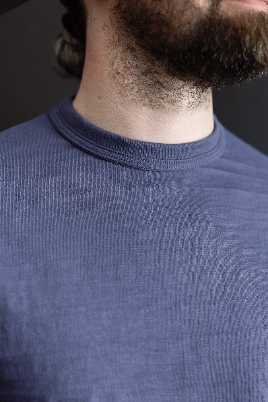 Close-up of front neckline and fabric texture, slubby cotton t-shirt, male model, athletic build.