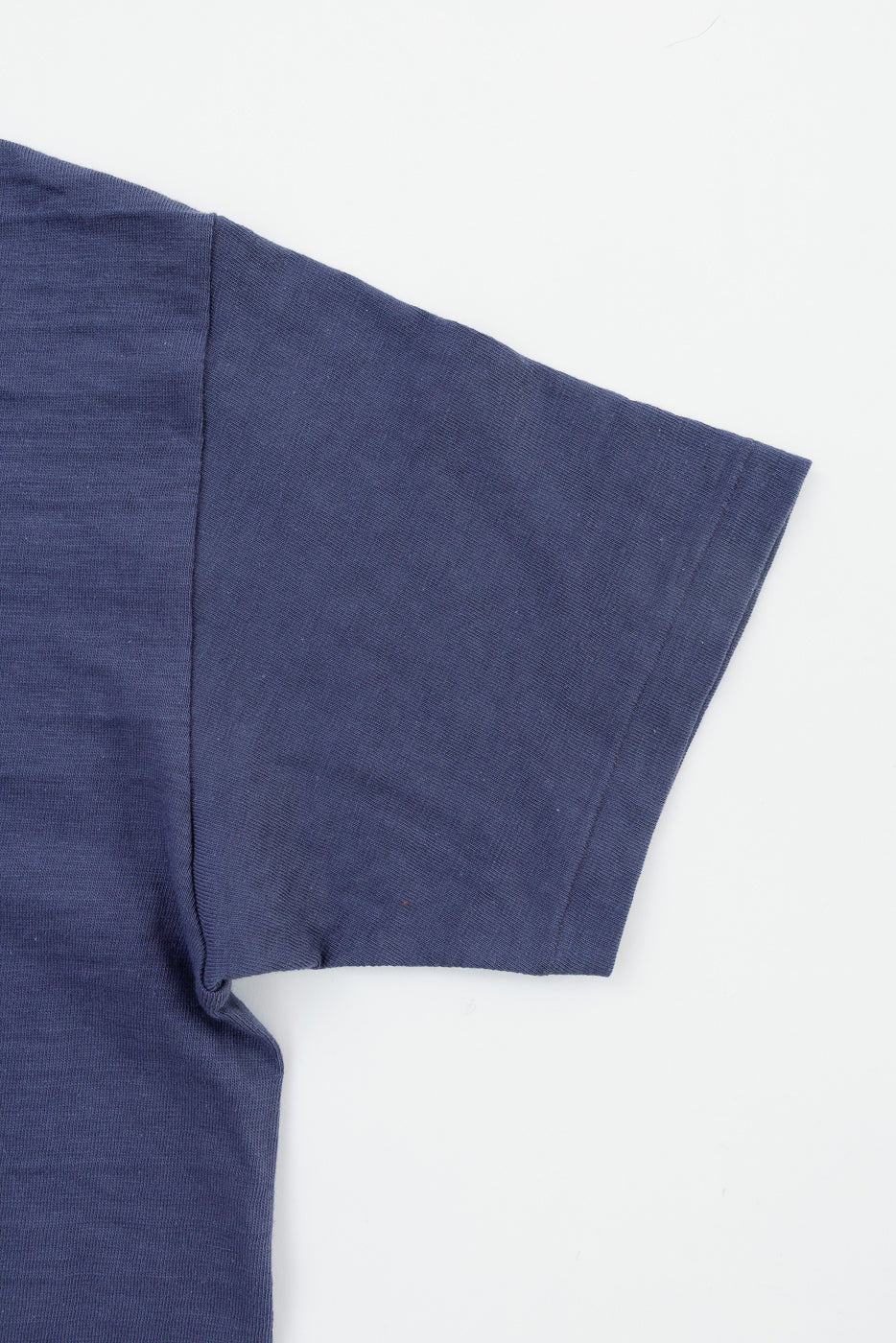 Close-up of right sleeve and side seam, heather eggplant slubby cotton T-shirt, flat lay